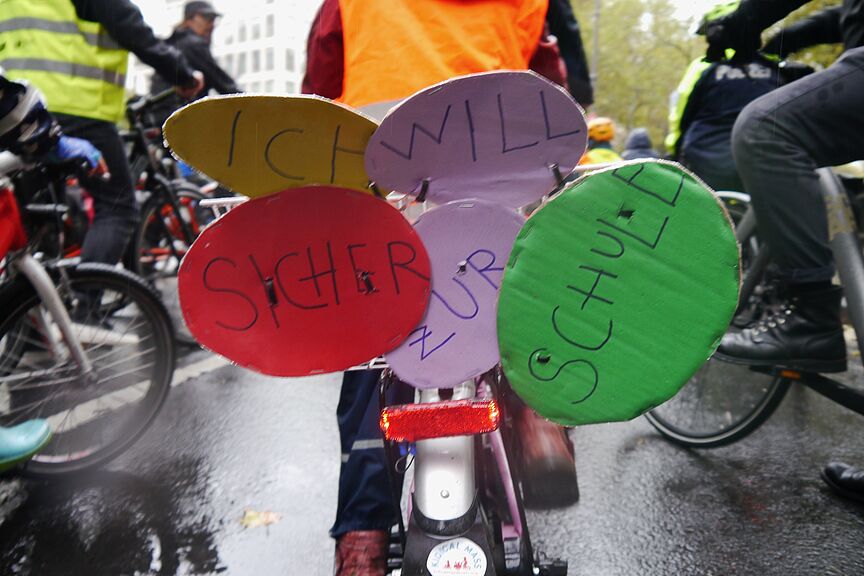 Kidical Mass - Ich will sicher zur Schule Kind auf Fahrrad mit Plakat "Ich will sicher zur Schule"