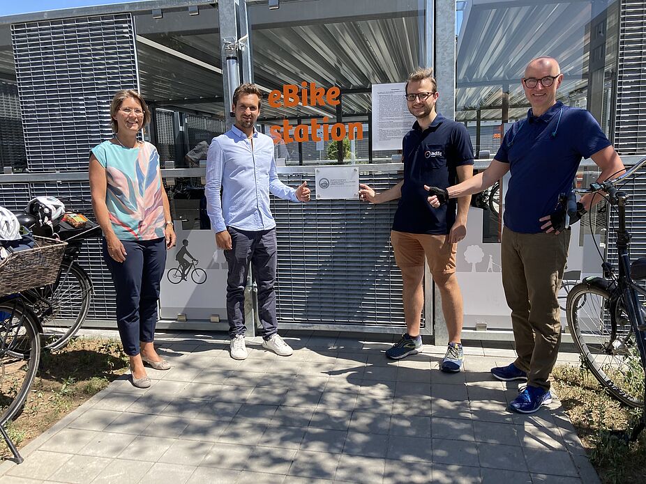 Übergabe der Zertifizierung Vier Personen stehen vor einer Plakette mit der Zertifizierung